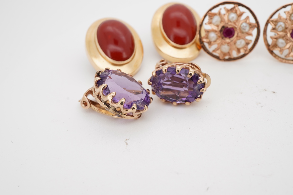 Three assorted modern pairs of ear clips including oval 750 yellow metal and carnelian, 19mm, unmarked yellow metal synthetic ruby and seed pearl and unmarked yellow metal and amethyst, together with a pair of 9ct and so